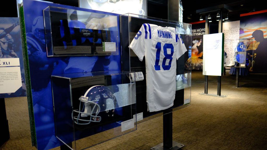 Game-worn jerseys hang in plastic cases, including one worn by the most famous Indianapolis Colt of all.