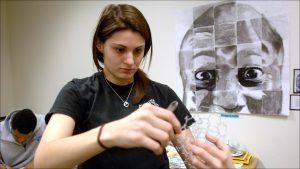 Student Stefani Amsden cuts wire for an art project. The school features unusual subject combinations, such as geometry-art.