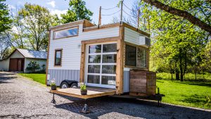 The tiny house includes a garage door that leads onto the deck to make home feel more open. A hatch in the loft leads to a roof-top deck.