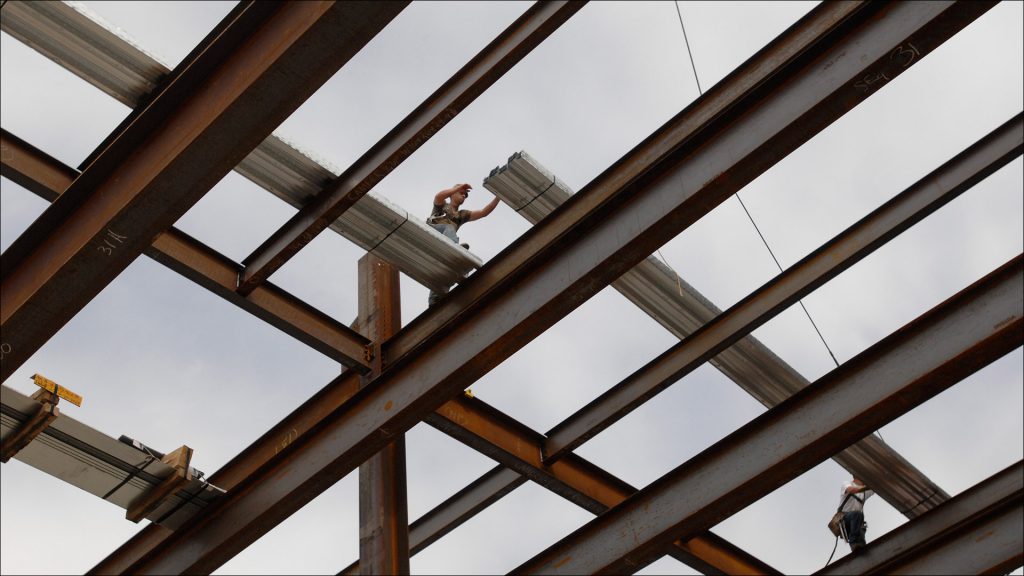 An iron worker maneuvers steel beams into place for the new hotel complex, which will feature 4 separate hotels.
