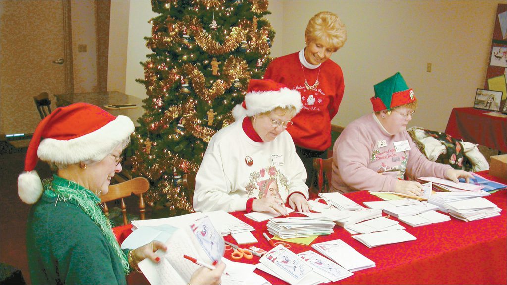 Members of the Christmas Lake Village Garden Club help Koch respond to letters to Santa.